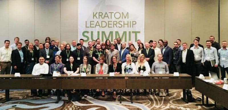 A group of people standing in front of a table.