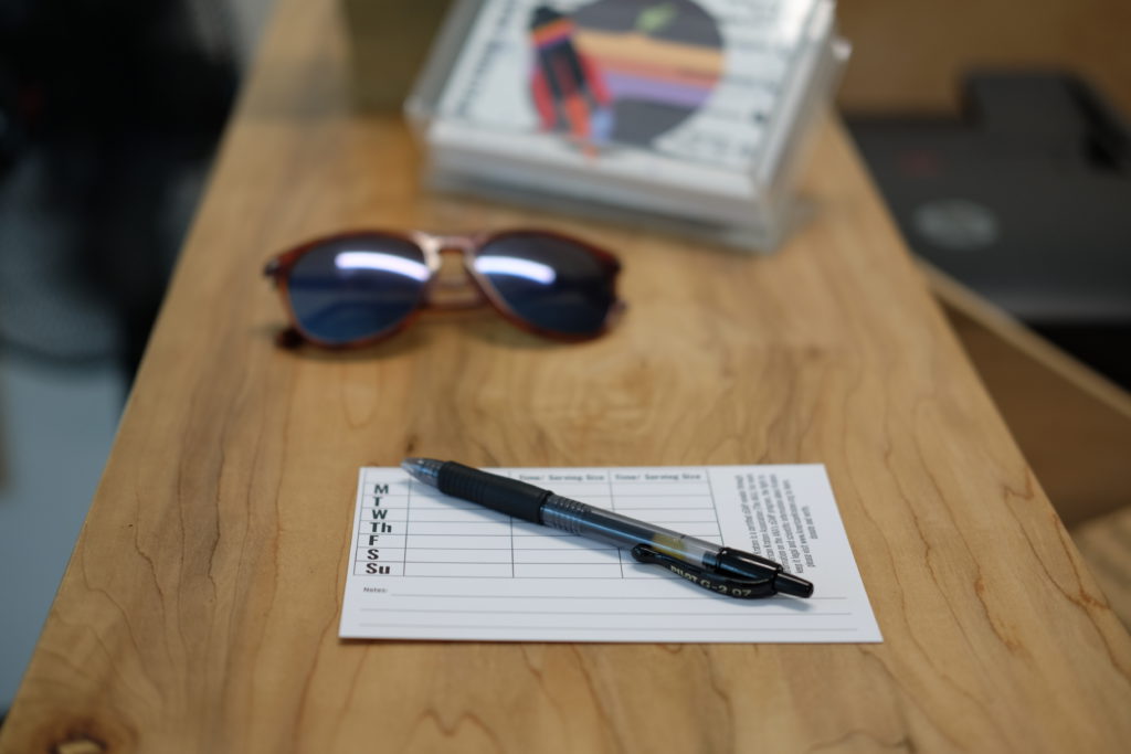 A pen and sunglasses on top of a table.