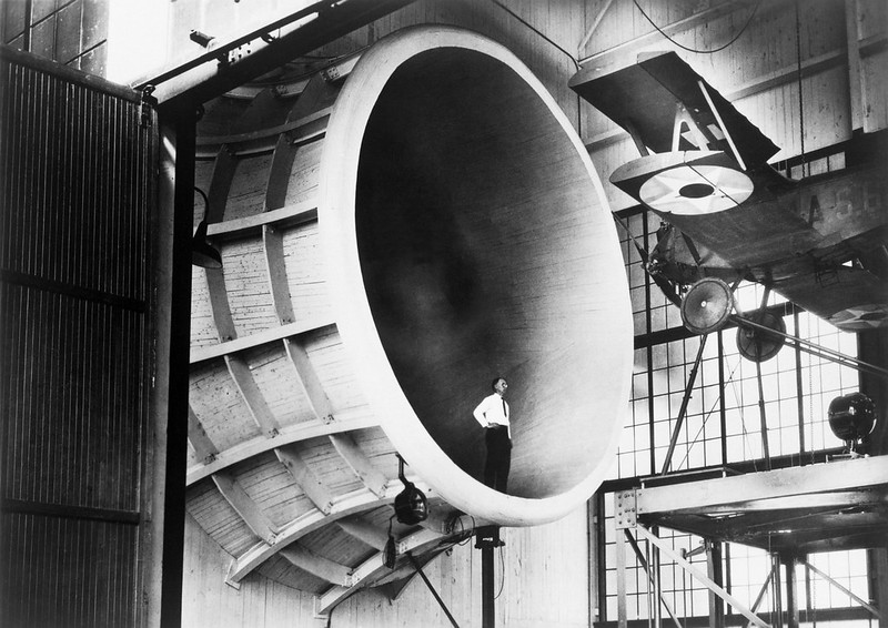 A man standing in front of an old looking machine.